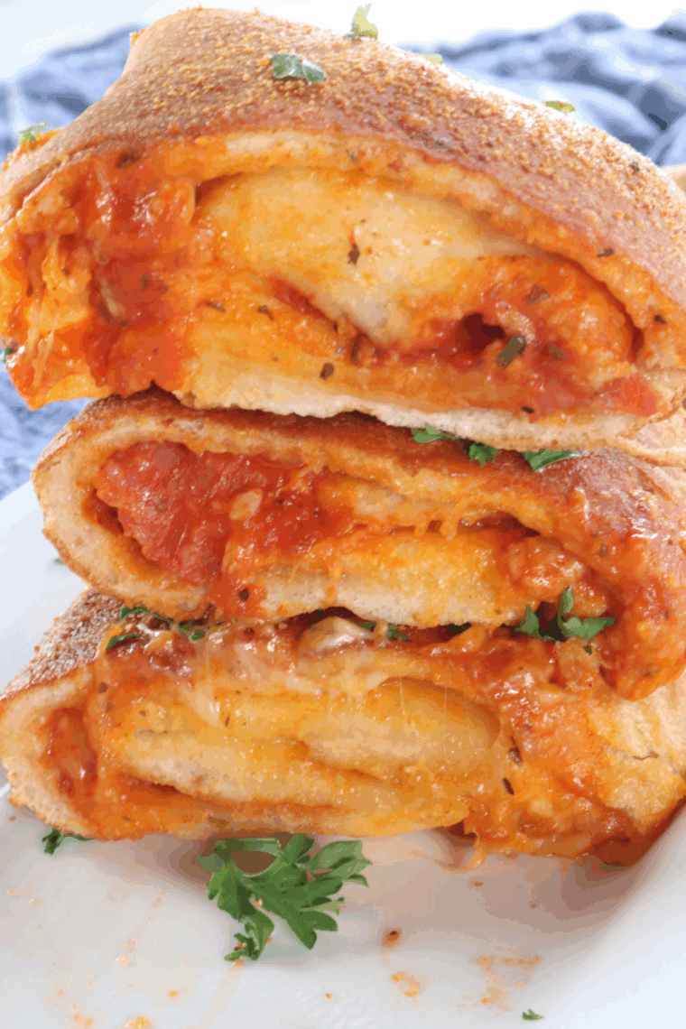 Air Fryer Pepperoni Stromboli sliced open, showing melted cheese and layers of pepperoni inside.