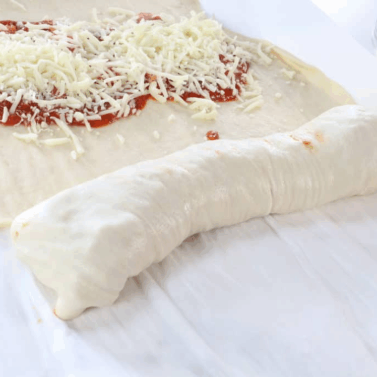 Pizza dough rolled into a log with ends tucked underneath to seal.