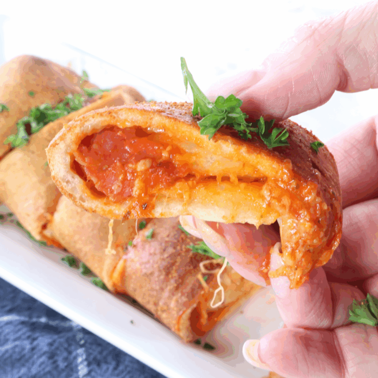 Golden-brown Air Fryer Pepperoni Stromboli sliced open, showing melted cheese and pepperoni inside.
