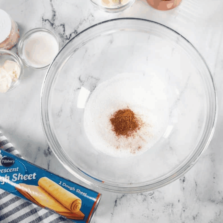 pumpkin spice sugar mixture with butter forming coarse crumbs on parchment lined air fryer