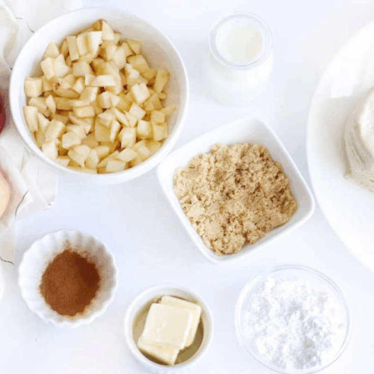 Ingredients needed for Air Fryer Apple Cinnamon Monkey Bread on kitchen table.