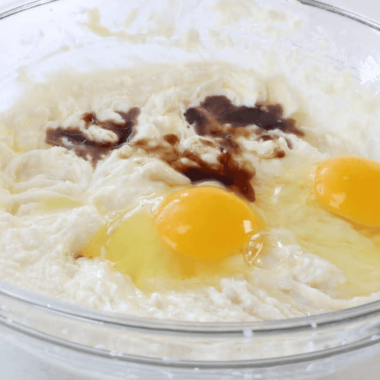 Eggs and vanilla being mixed into creamed butter and sugar for Air Fryer Lofthouse Cookies.