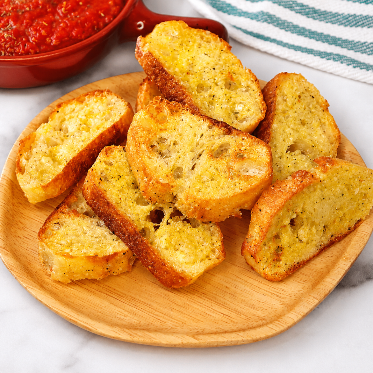 Air fryer crostini topped with whipped ricotta and honey on a wooden board