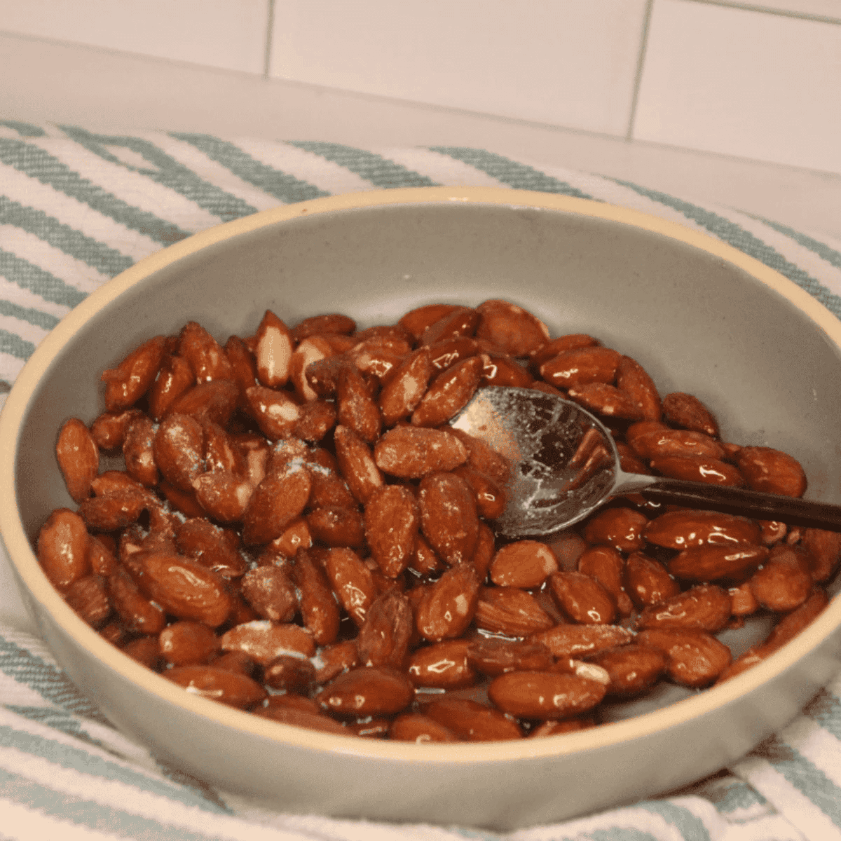 Almonds tossed with honey, sugar, and salt in a bowl until coated