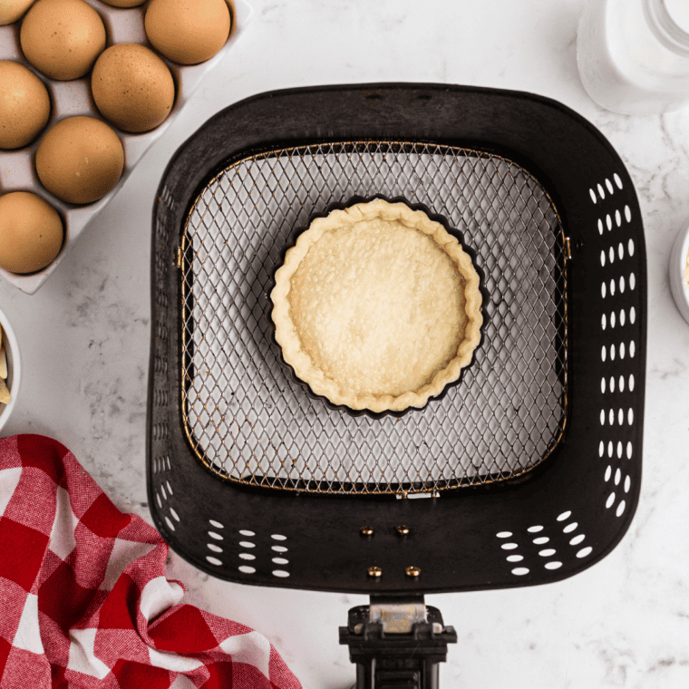  Pie crust pressed into a tart pan with the edges trimmed even to the rim.