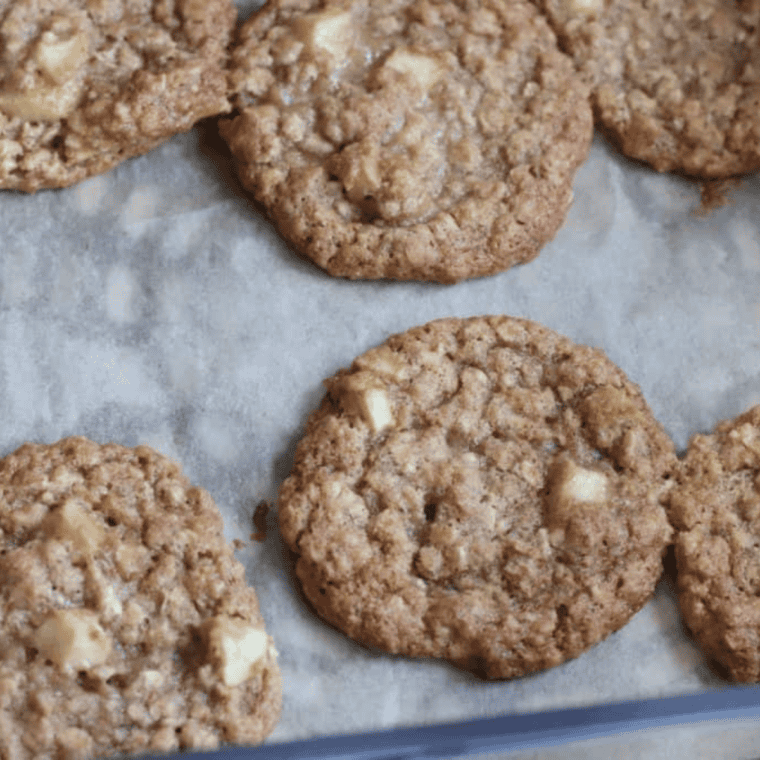 Air fryer apple cinnamon oatmeal cookies spaced on parchment paper, cooling on wire rack after 6&ndash;8 minute air frying.