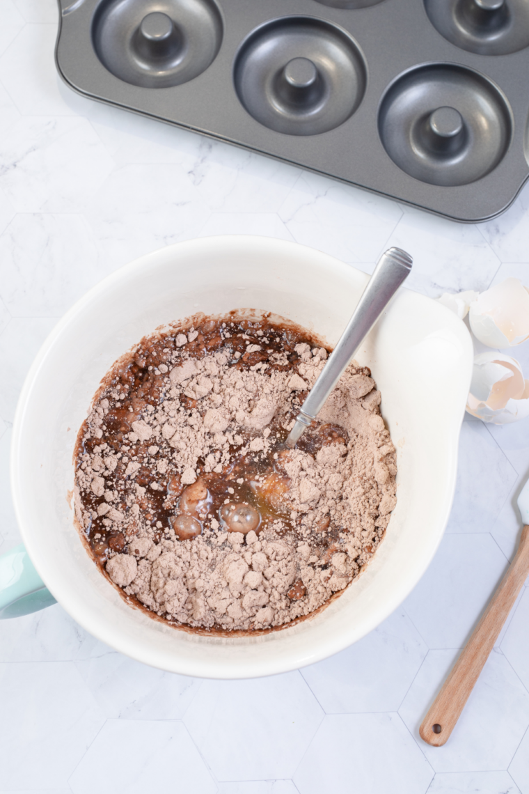 mixing brownie batter in bowl with eggs oil and chocolate chips