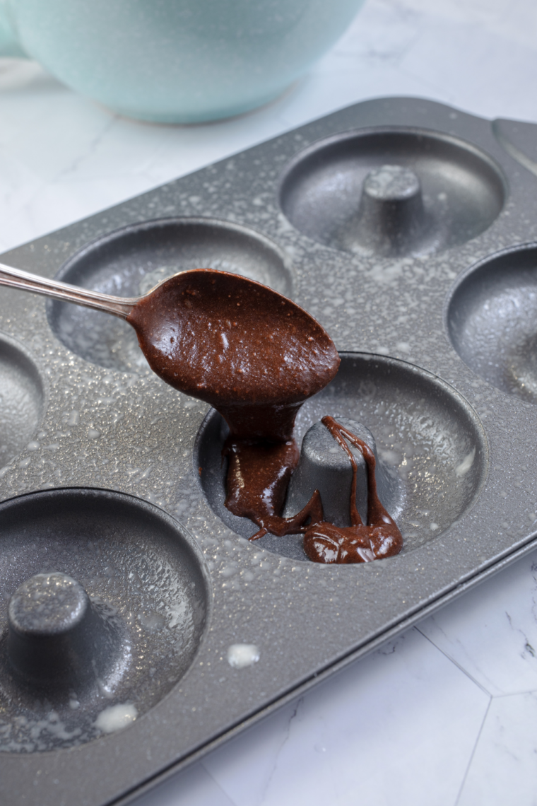 filling silicone donut mold with brownie batter using piping bag