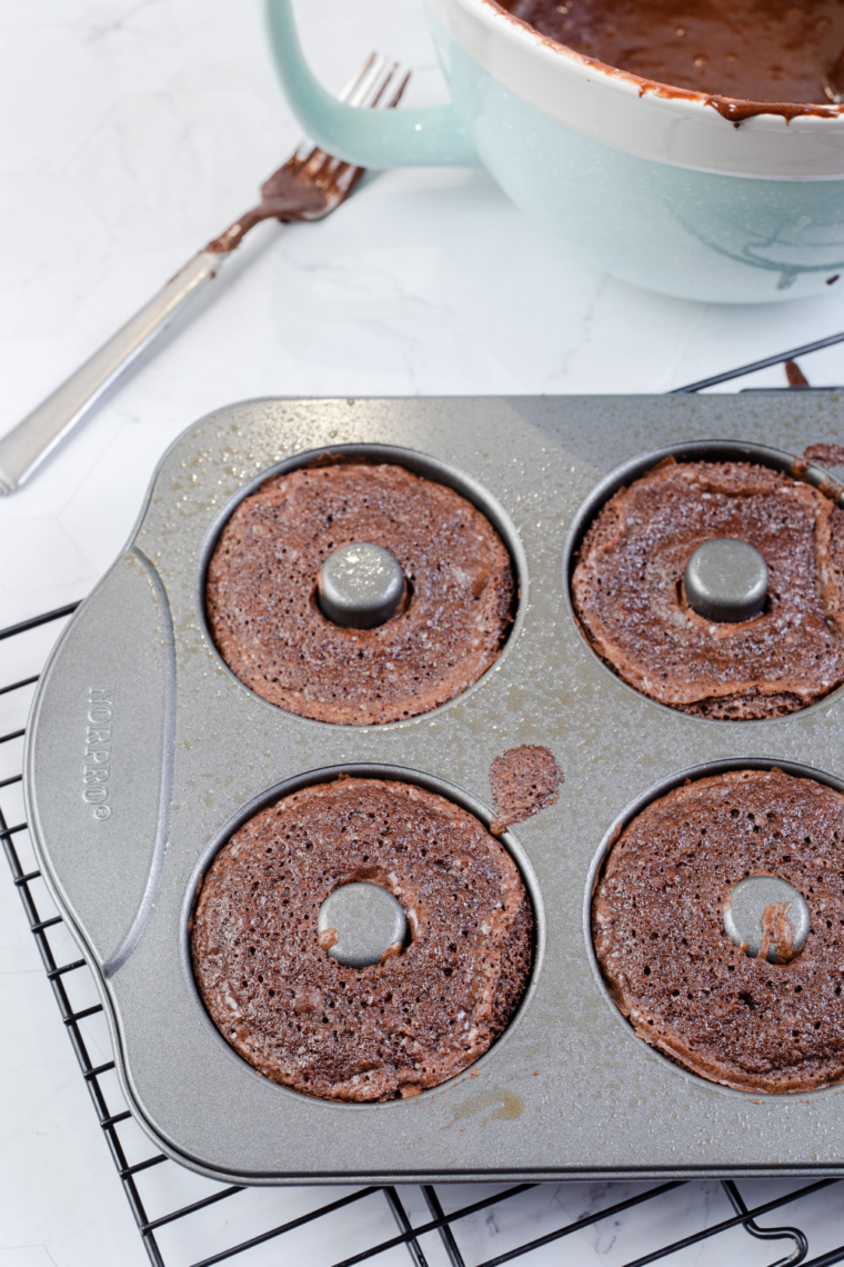 preparing air fryer donut mold with brownie batter and tapping to remove bubbles