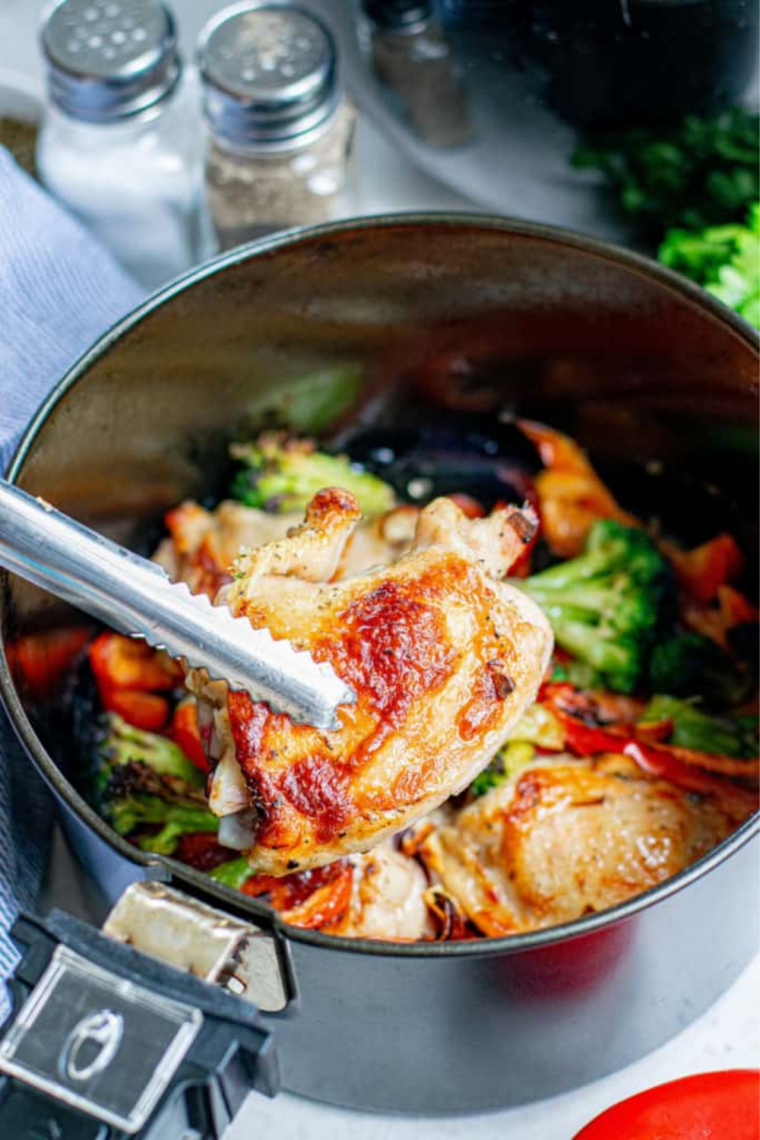 Bone-in chicken thighs skin side up in an air fryer basket, skin crisped and golden
