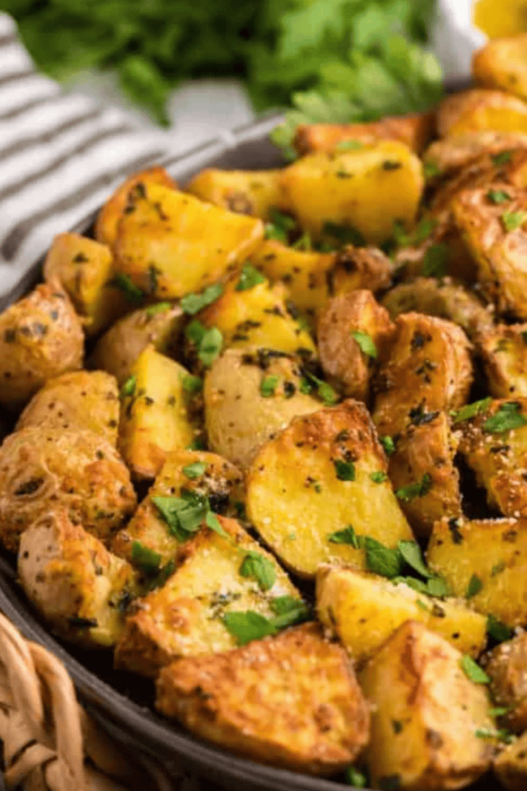 Crispy lemon and oregano Greek potatoes fresh from the air fryer, garnished with parsley.