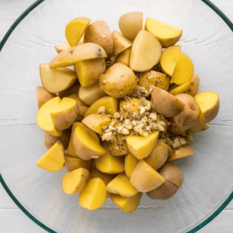 Raw potatoes cut into even 1-inch chunks on a cutting board for Air Fryer Greek Lemon Potatoes.