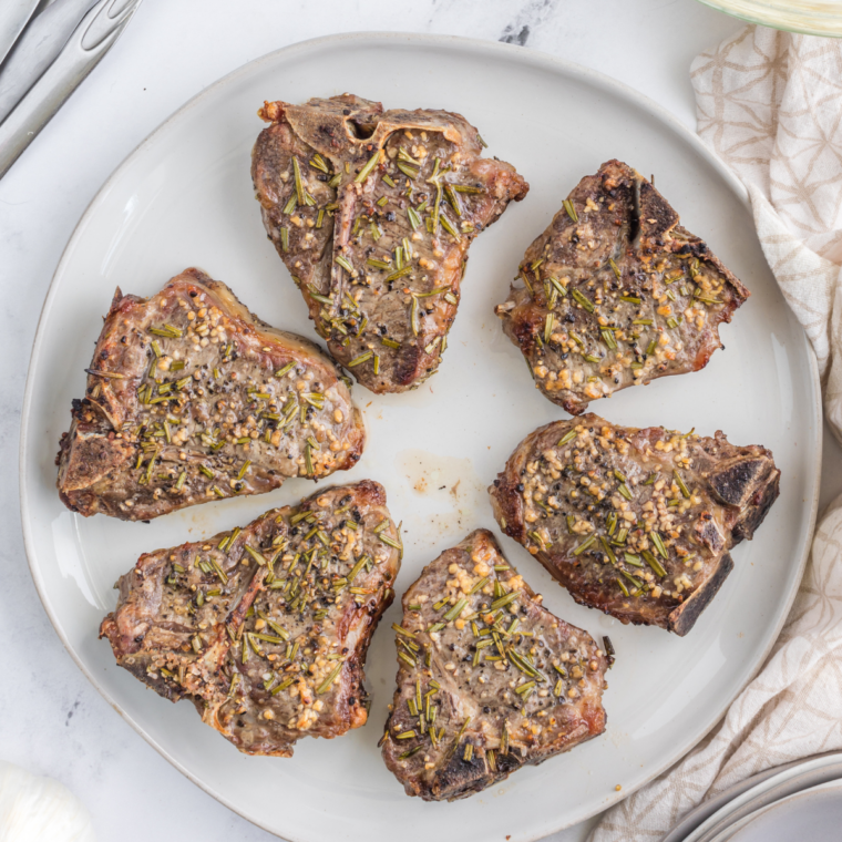  Air-Fryer-Rosemary-Lamb-Chops-22-of-22 (currently empty)
Cooked air fryer lamb chops resting on a plate, seared outside and juicy pink inside