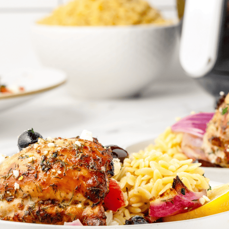 Finished Air Fryer Greek Chicken with summer vegetables seasoned and served warm on a plate