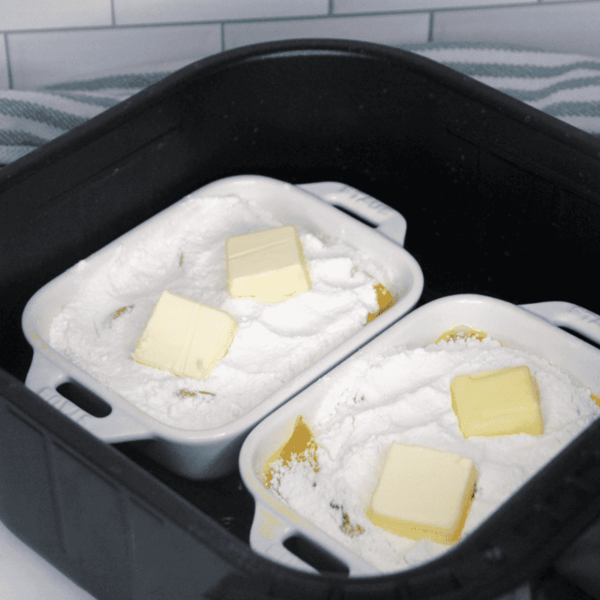 Layering peaches in ramekins, topping with cake mix and butter.