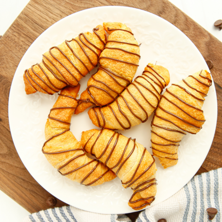 Baked peanut butter chocolate crescent rolls resting on a plate with melted chocolate inside