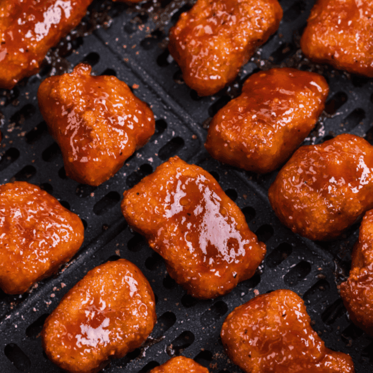 Salmon bites cooking in the air fryer until opaque and lightly caramelized