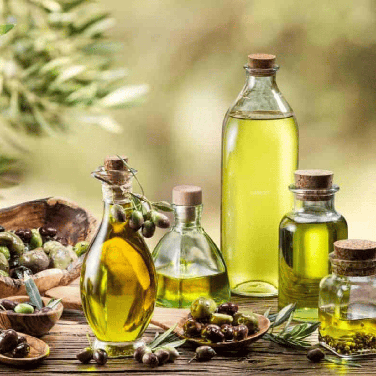 An assortment of cooking oils for air fryer use — avocado, olive, and vegetable oil — on a wooden kitchen counter