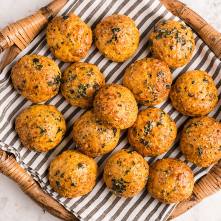 Golden air fryer cheese puffs piled on a plate with a crispy exterior and soft cheesy center