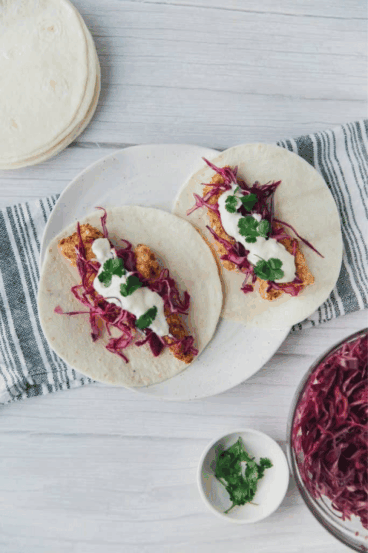 Crispy blackened tilapia strips in tacos topped with fresh cabbage slaw.