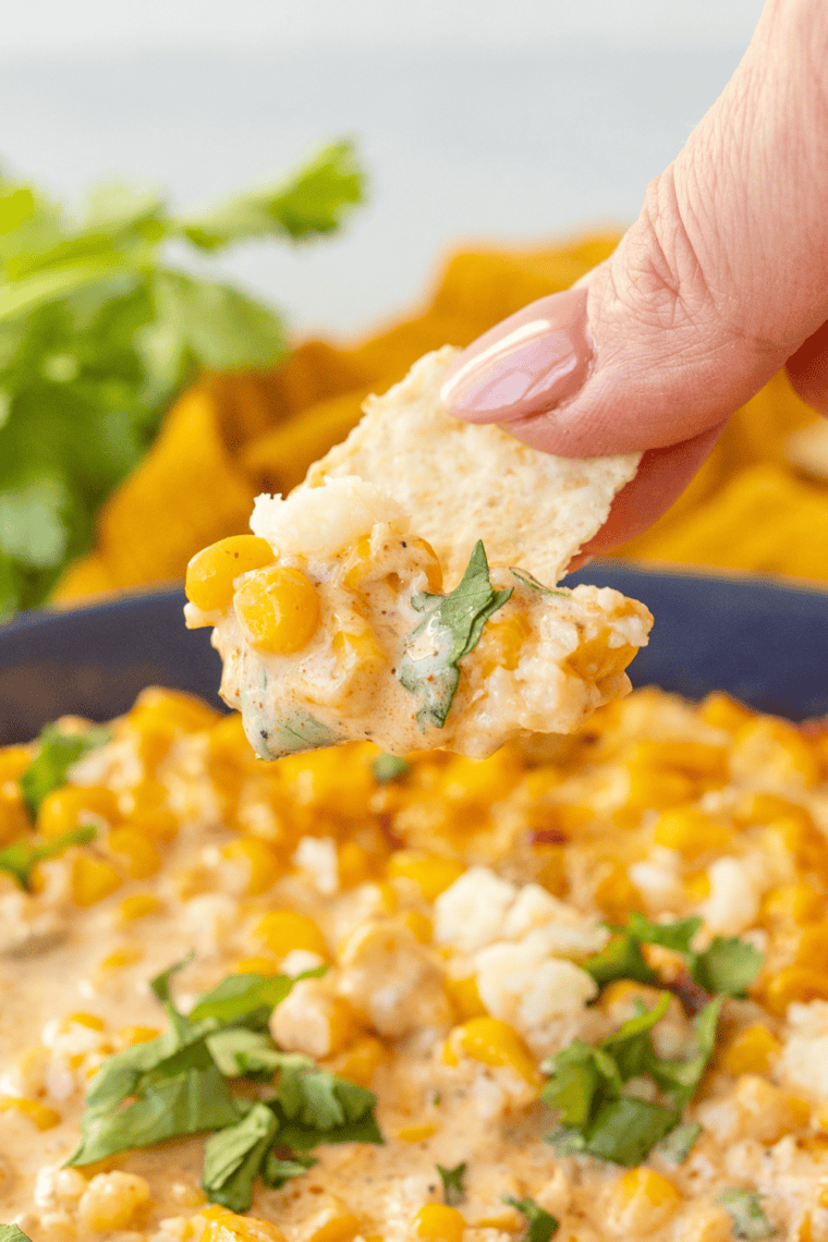 Creamy air fryer elote dip made with roasted corn, Cotija cheese, Mexican cheese blend, and cilantro served warm with tortilla chips for dipping
