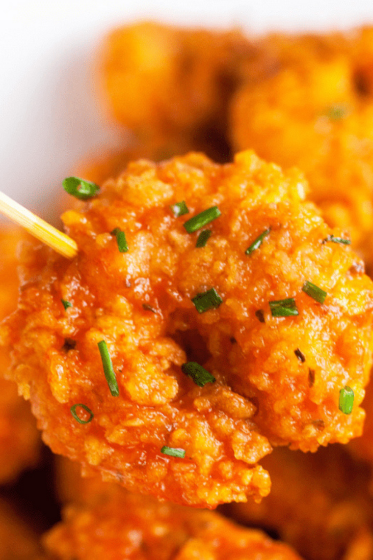 Shrimp coated in seasoned flour mixture resting in a bowl in the refrigerator.