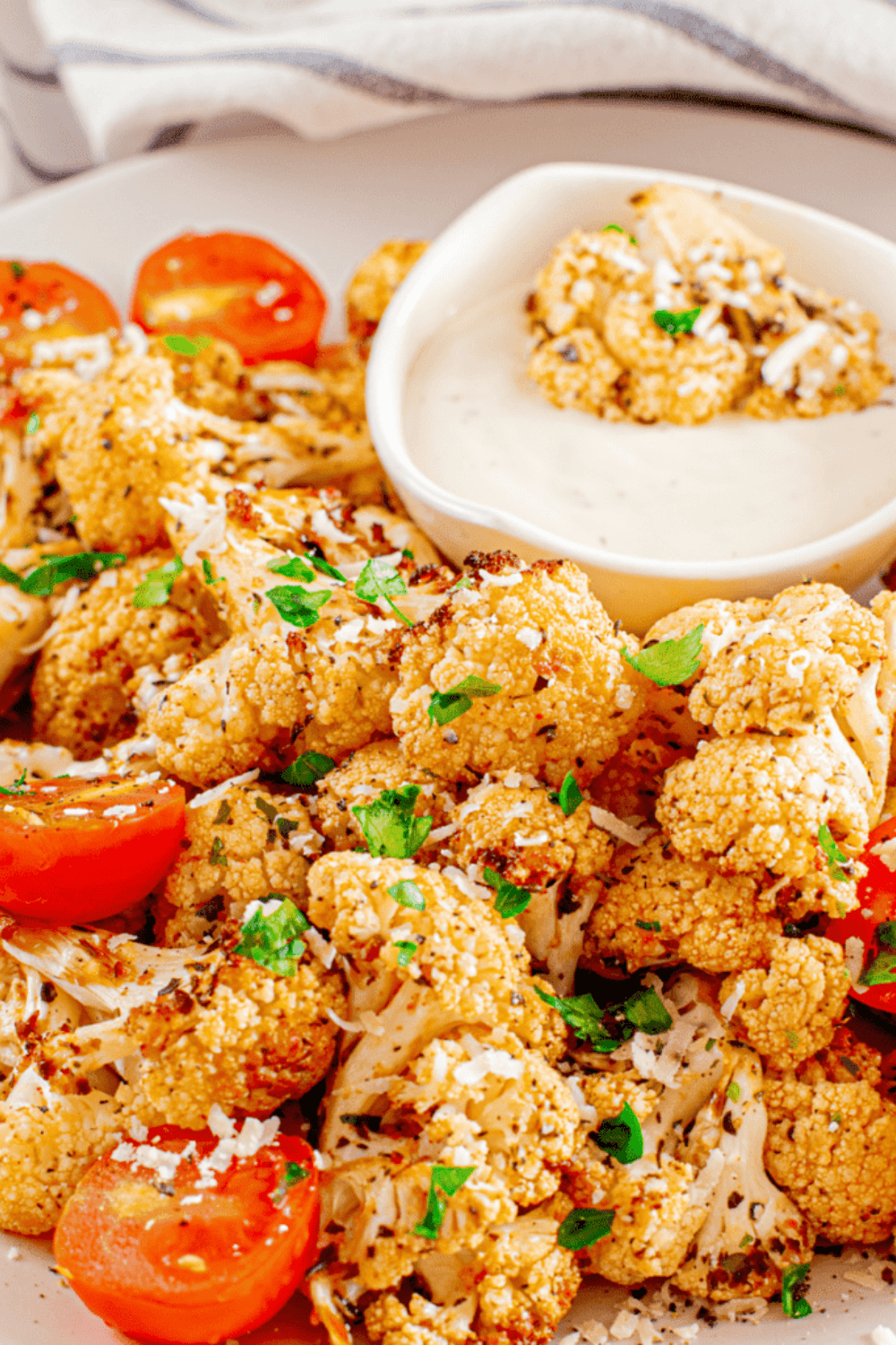 Golden air fryer cauliflower florets mixed with roasted cherry tomatoes in a bowl, ready to serve.