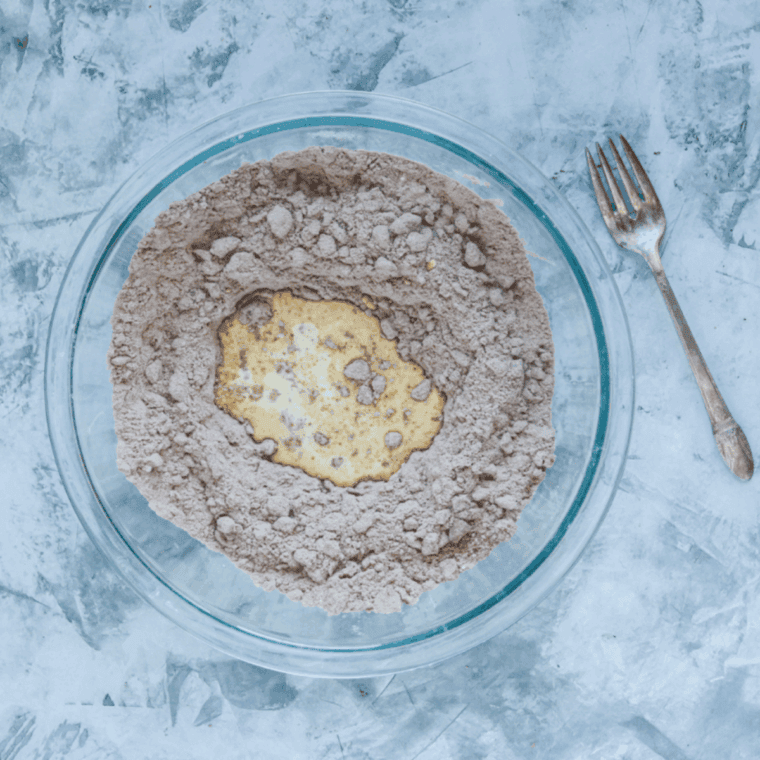 Mixing chocolate shortcake dough with flour, cocoa powder, butter, and cream in a bowl