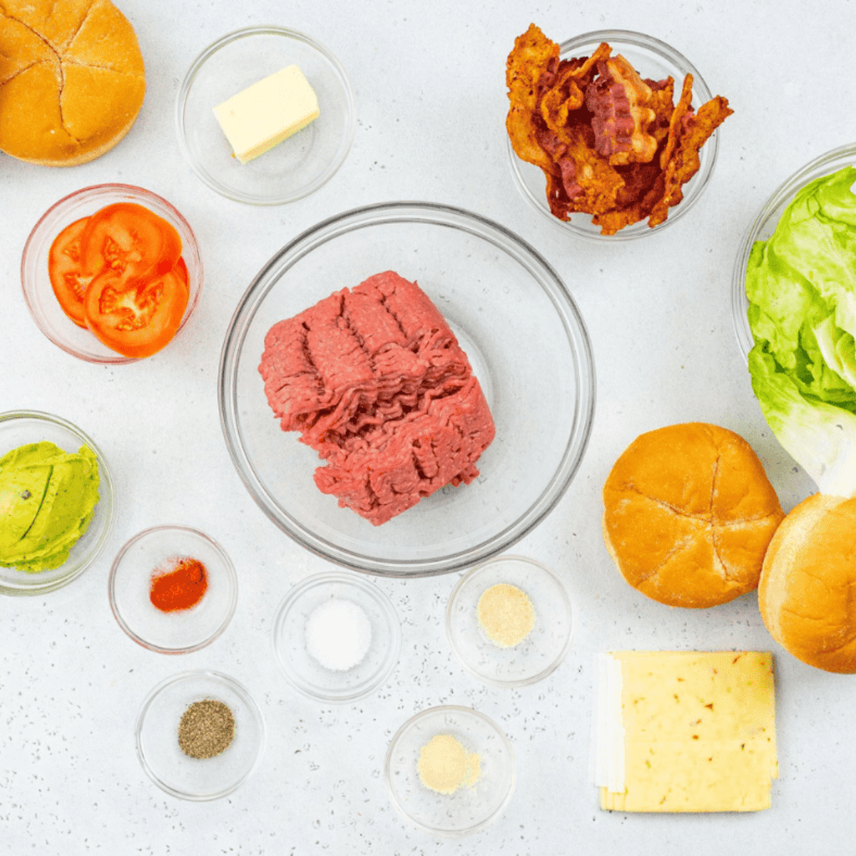 Ingredients needed for Air Fryer Guacamole Bacon Burger on kitchen table.
