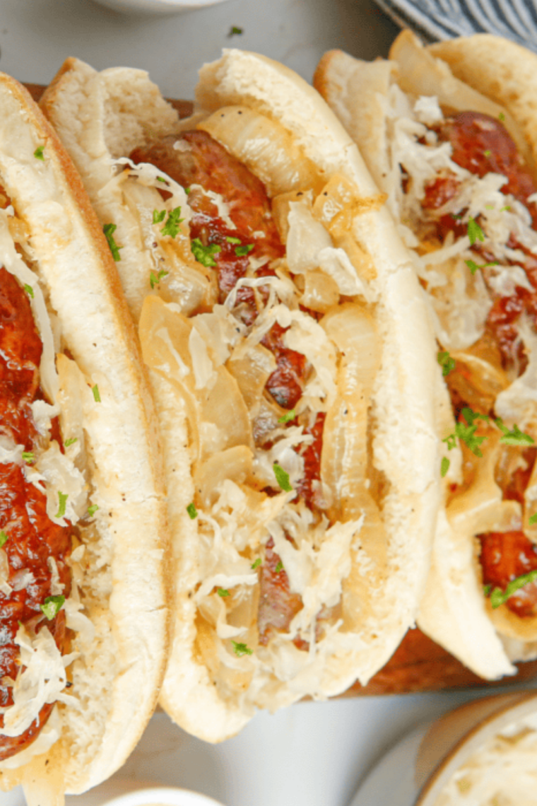 Air fryer hot dogs in buns topped with sauerkraut and mustard, served New York style and ready to eat.