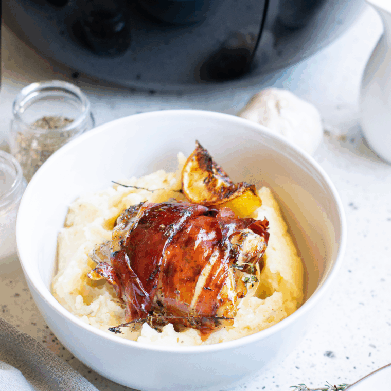 Air fryer bacon wrapped chicken thighs served on a plate