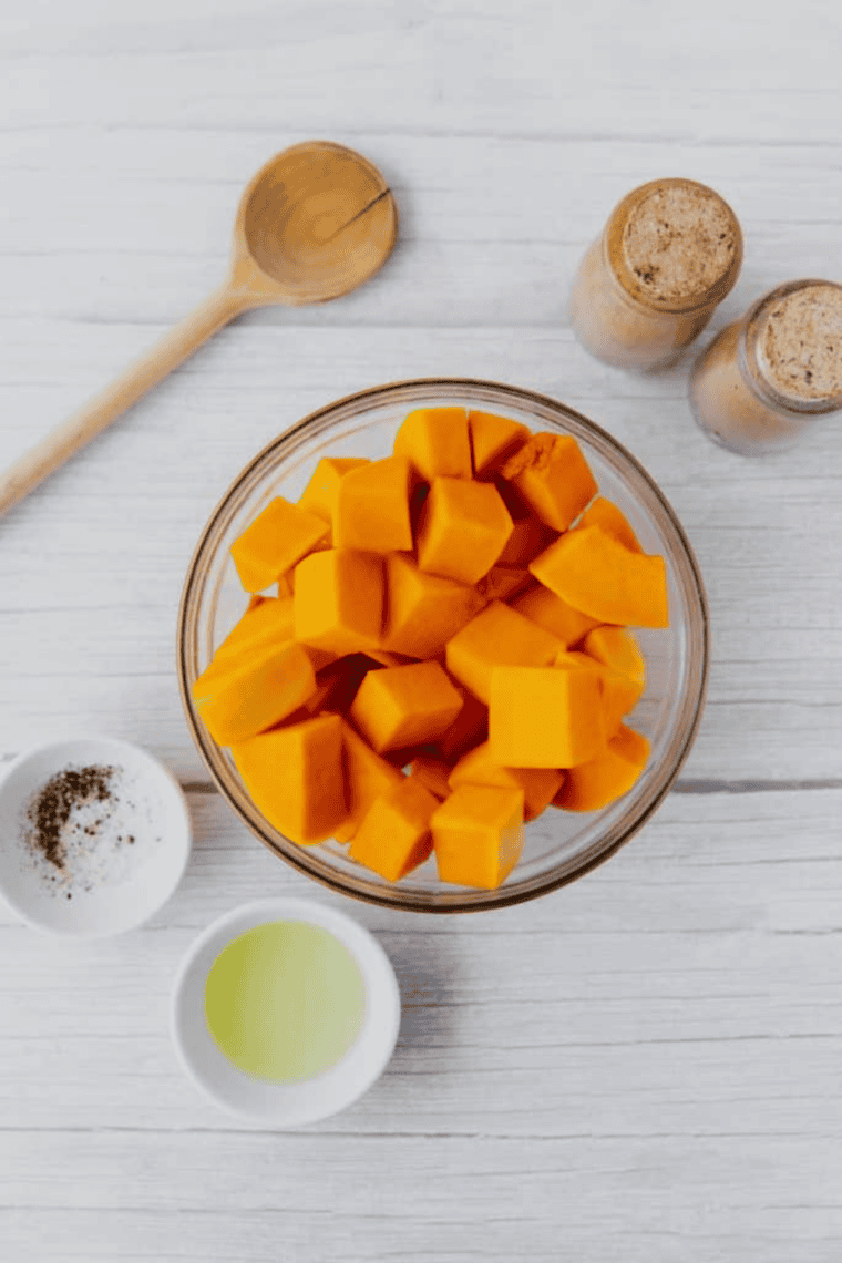 Peeled white sweet potatoes being cut into even cubes for uniform cooking