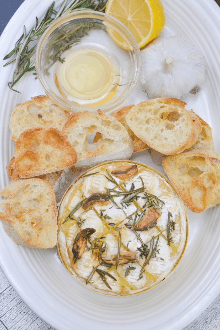 Golden baked Camembert cheese in an air fryer, ready to serve with bread and crackers.