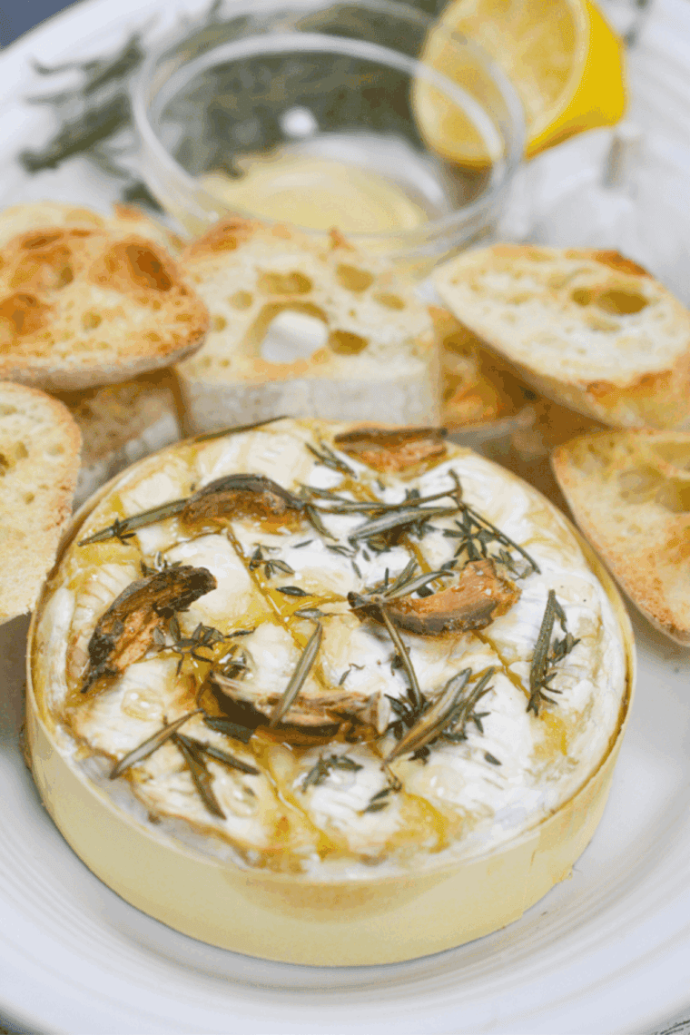 easy air fryer baked camembert with fresh herbs and honey served warm in a small dish