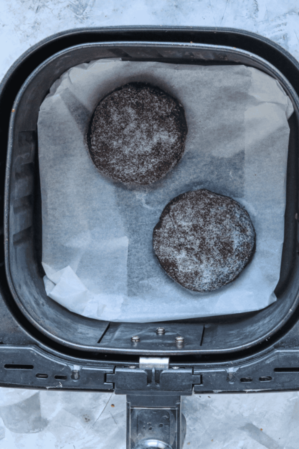 Chocolate shortcakes baking in air fryer on parchment paper, cooling after cooking