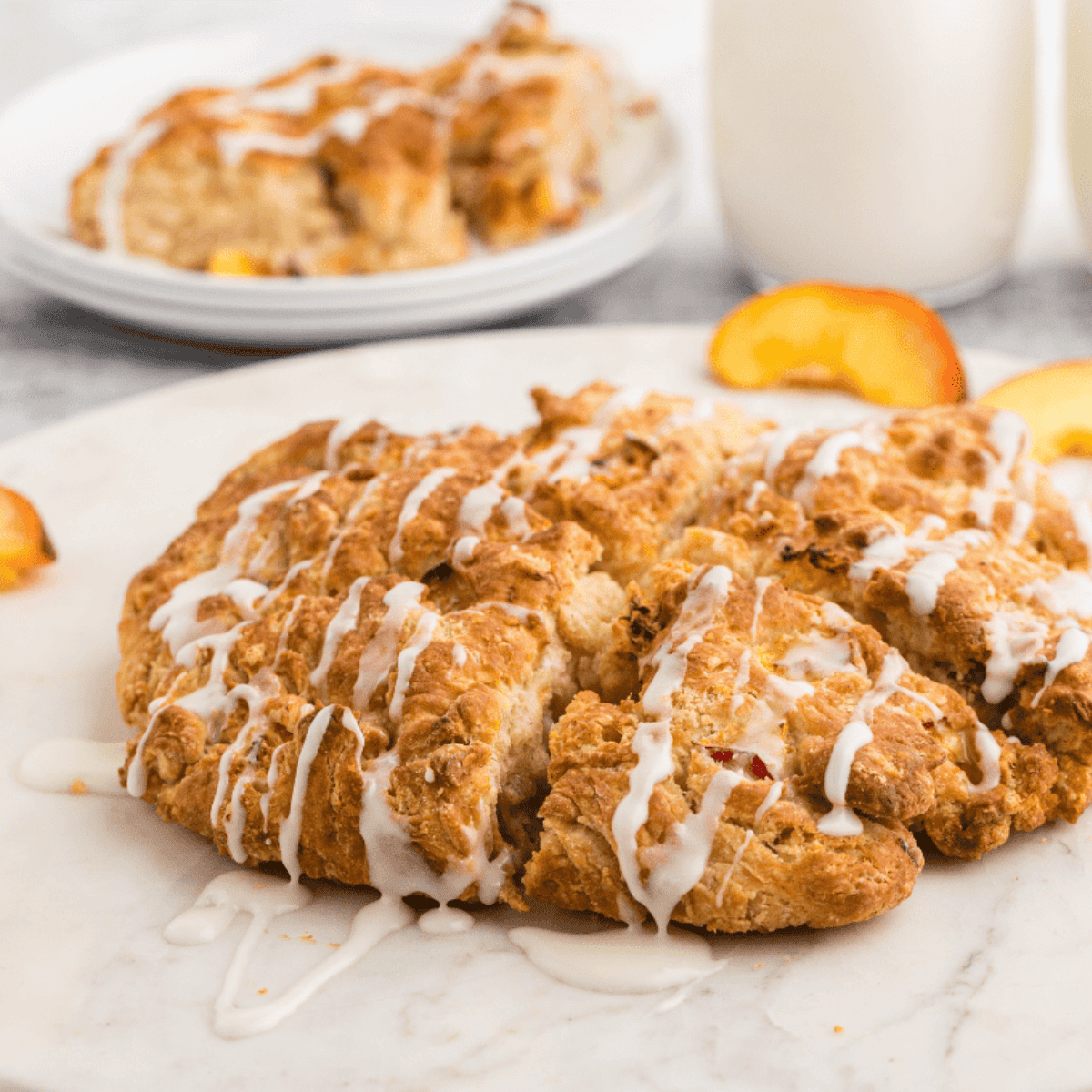 Golden, fluffy peach scones fresh from the air fryer, served on a plate.