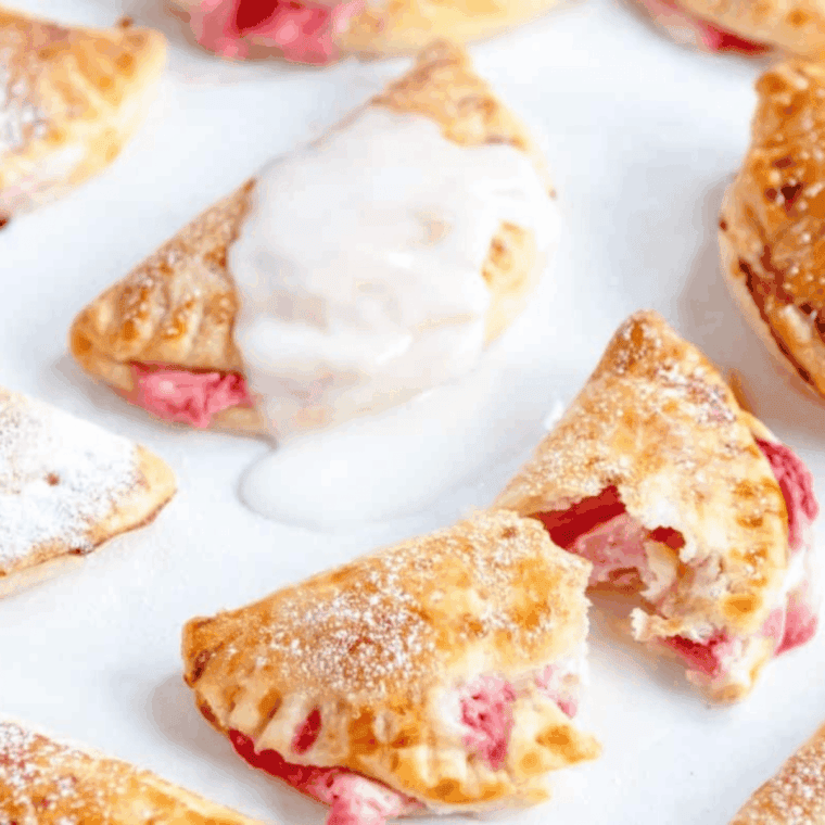 Golden, flaky air fryer strawberry hand pies with sweet strawberry filling on a plate.
