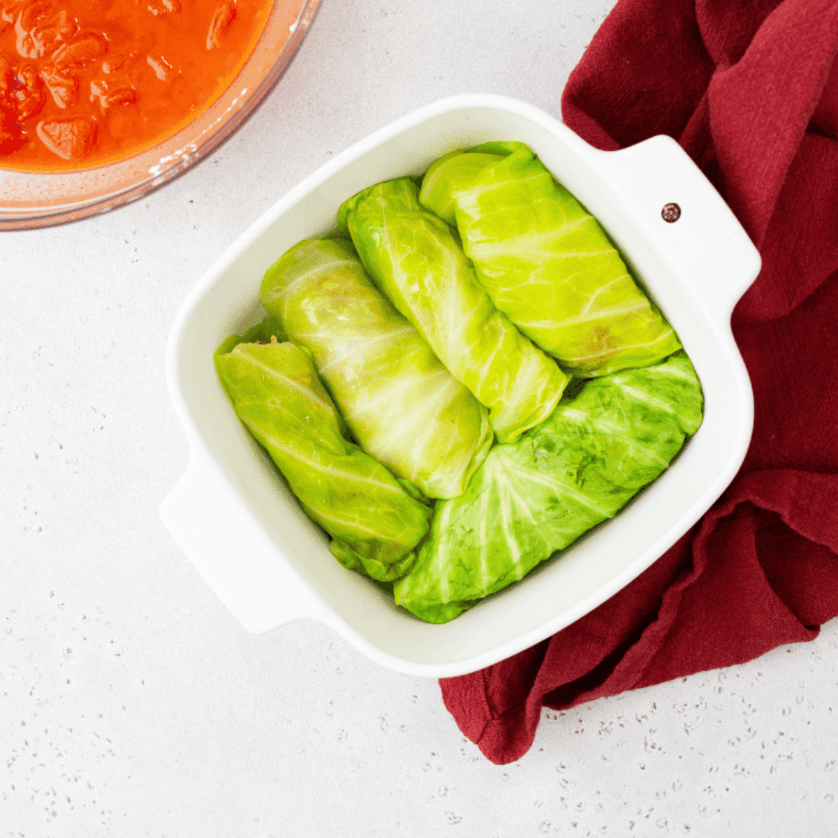Arranging the prepared cabbage rolls onto a greased oven-safe dish, ready for cooking.