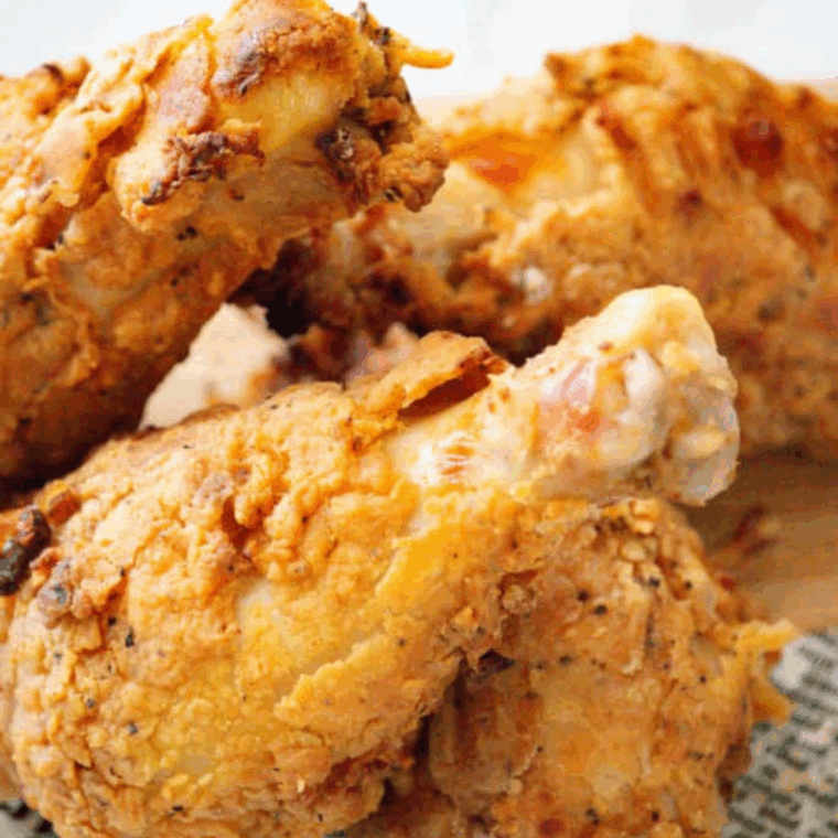 Golden chicken cooking in Ninja Foodi air fryer with crispy coating