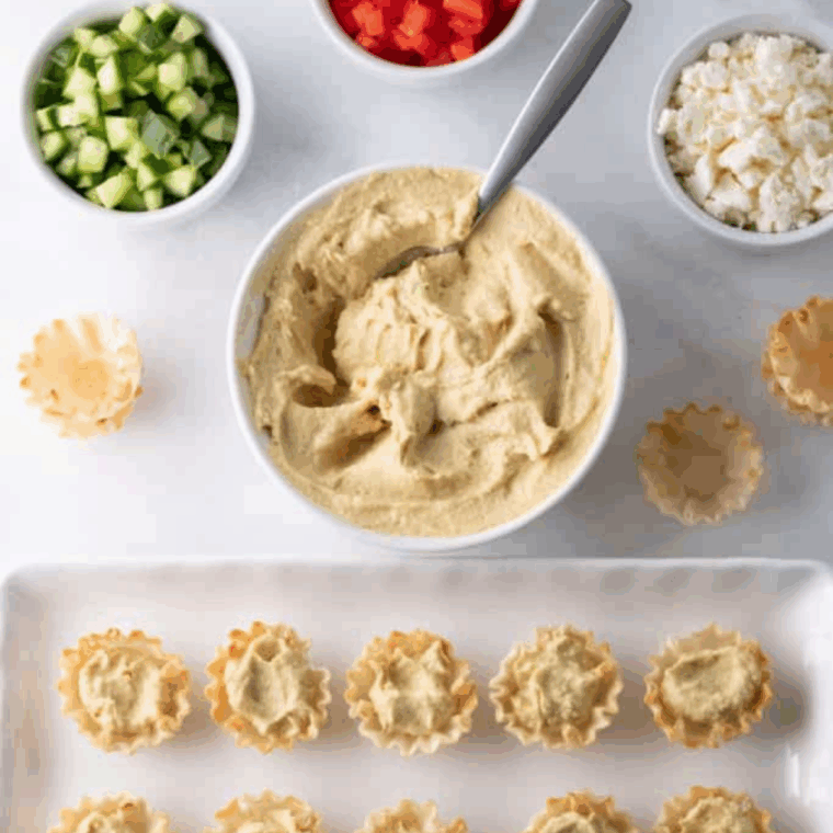Ingredients needed for Greek Hummus Phyllo Bites on kitchen table.
