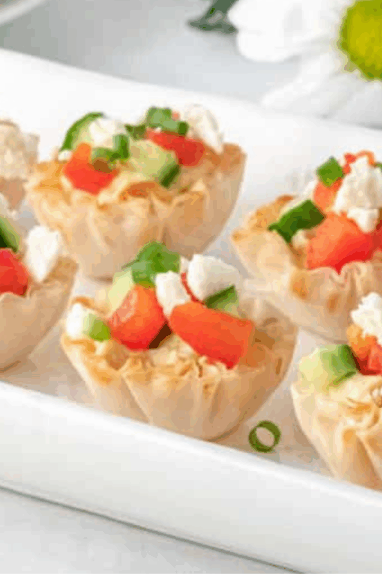 Greek hummus phyllo bites with creamy hummus, red bell pepper, cucumber, and crumbled feta on a serving platter