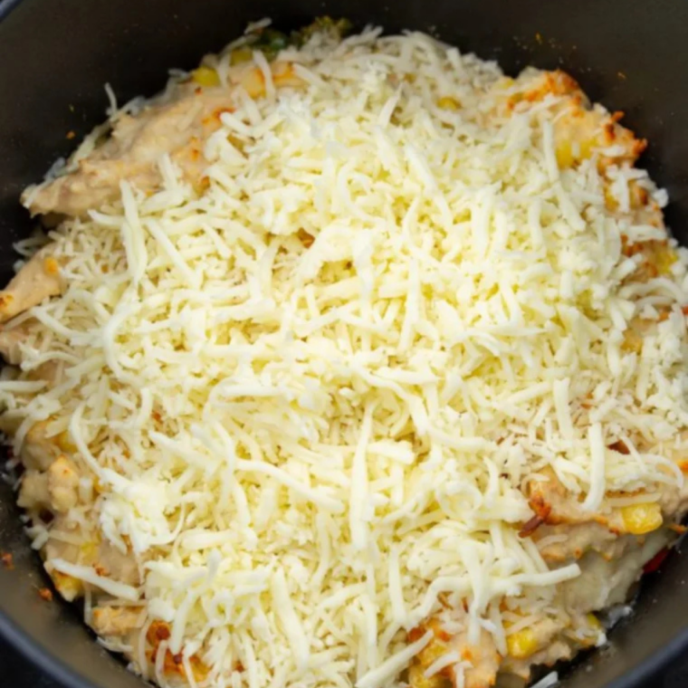 Reserved white beans, diced red bell pepper, and salsa verde layered in the bottom of a cast iron skillet