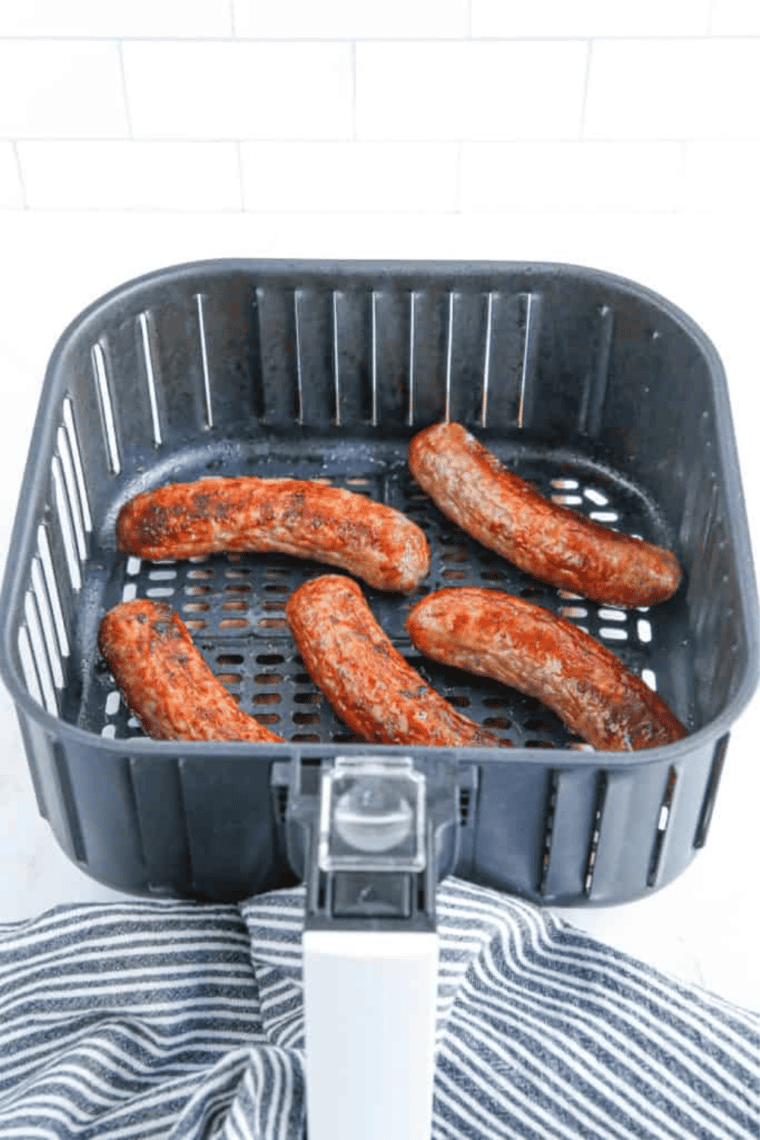 Frozen brats arranged in a single layer in an air fryer basket