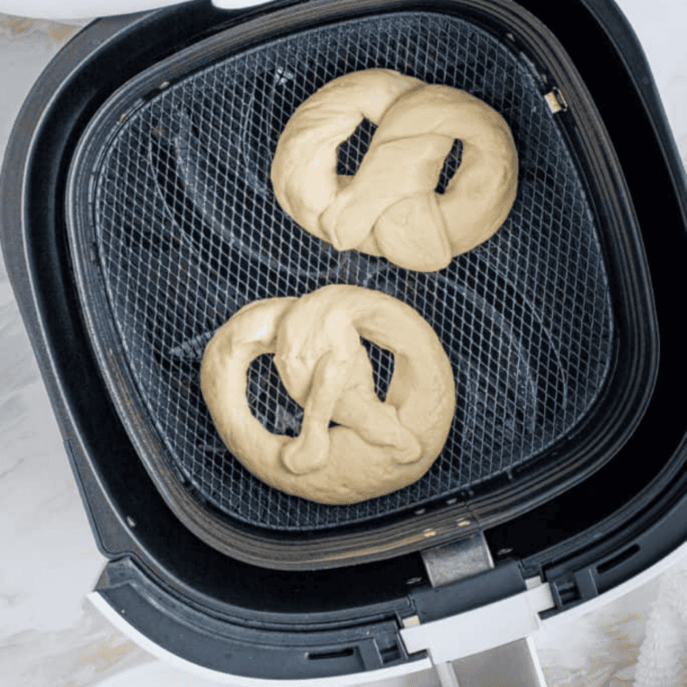 Soft pretzels air frying to golden brown in the air fryer basket