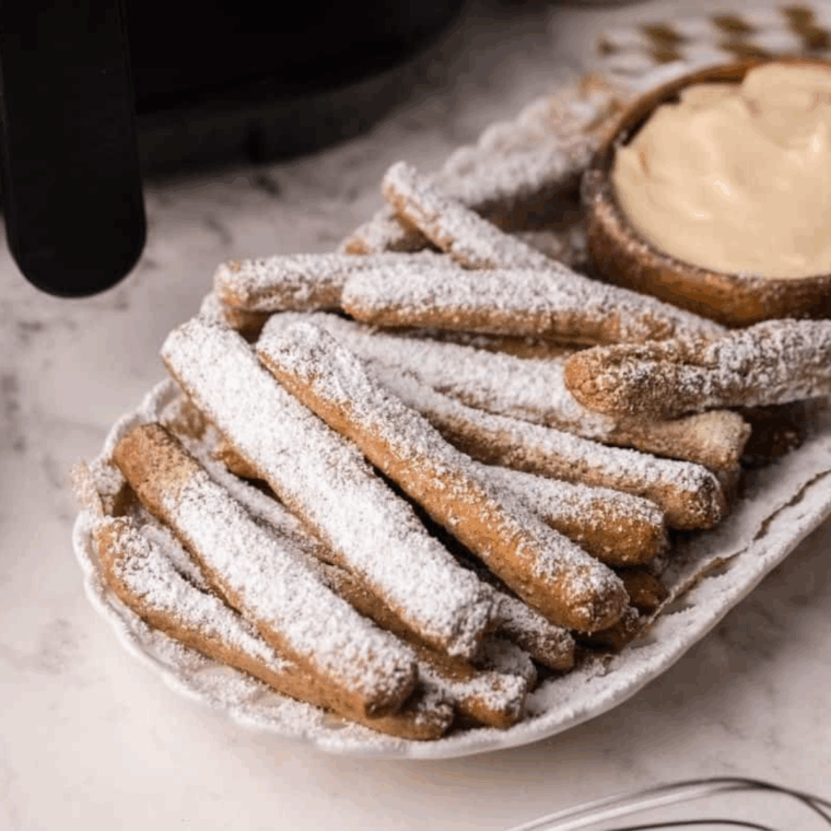 Air Fryer Funnel Cake Fries are a fun, crispy twist on the classic fair treat, made quickly and easily in your air fryer. These golden, crunchy fries are dusted with powdered sugar for the perfect sweet snack or dessert. With minimal oil and fast cooking, they’re a lighter and healthier way to enjoy funnel cake at home!