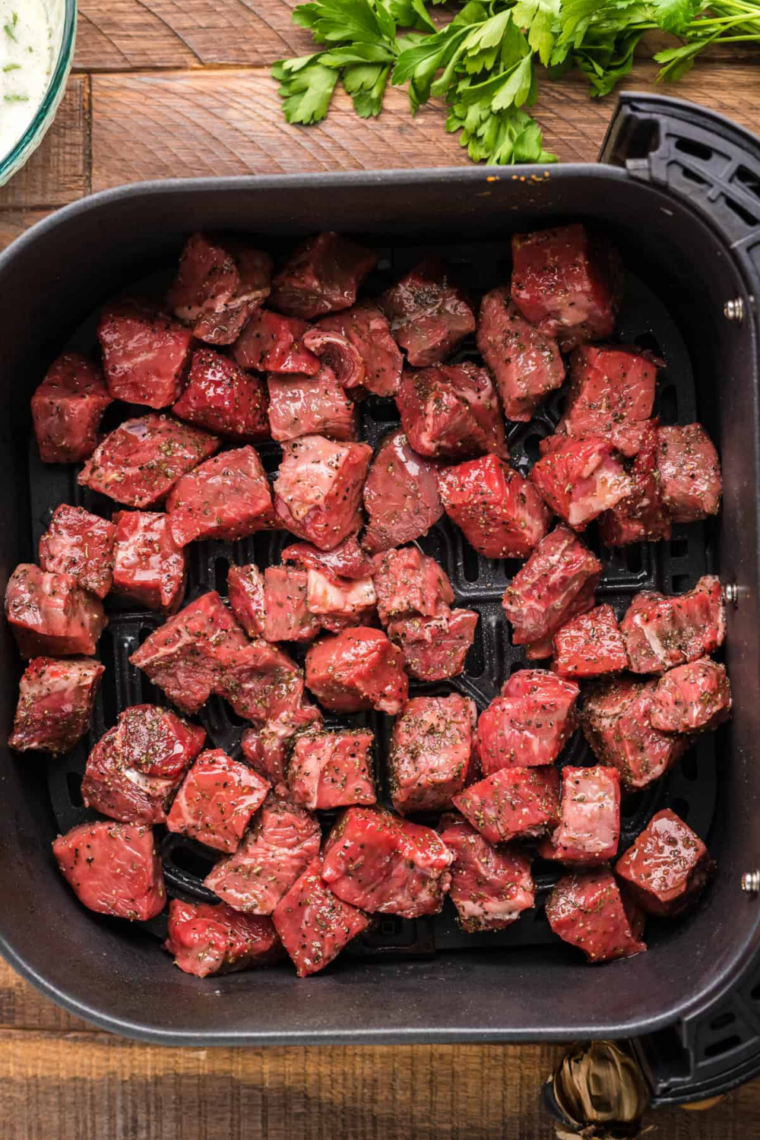 Air fryer preheating to 400 degrees with an empty basket to ensure a hot surface for searing steak bites.