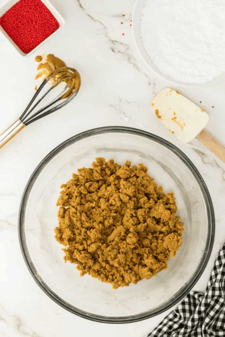 Thick gingerbread cookie dough being mixed with a rubber spatula until combined.