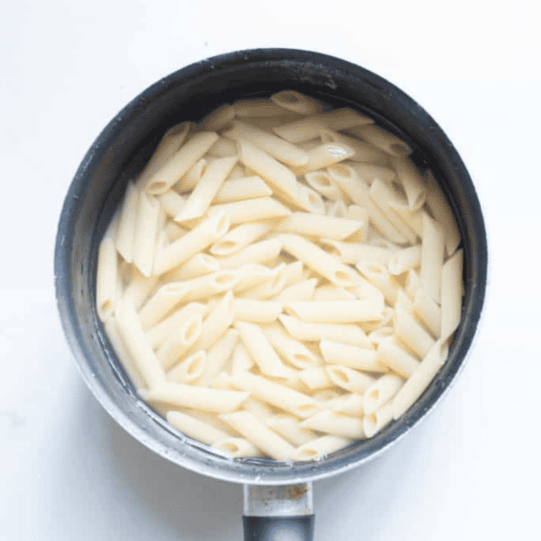 Short pasta cooking in a large pot of salted boiling water on the stovetop until al dente.