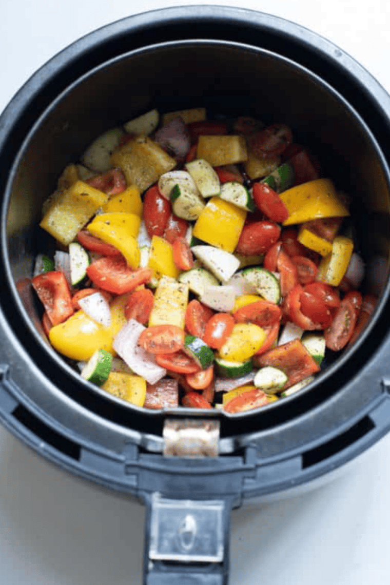 Seasoned vegetables arranged in a single layer in the air fryer basket ready to roast at 400 degrees