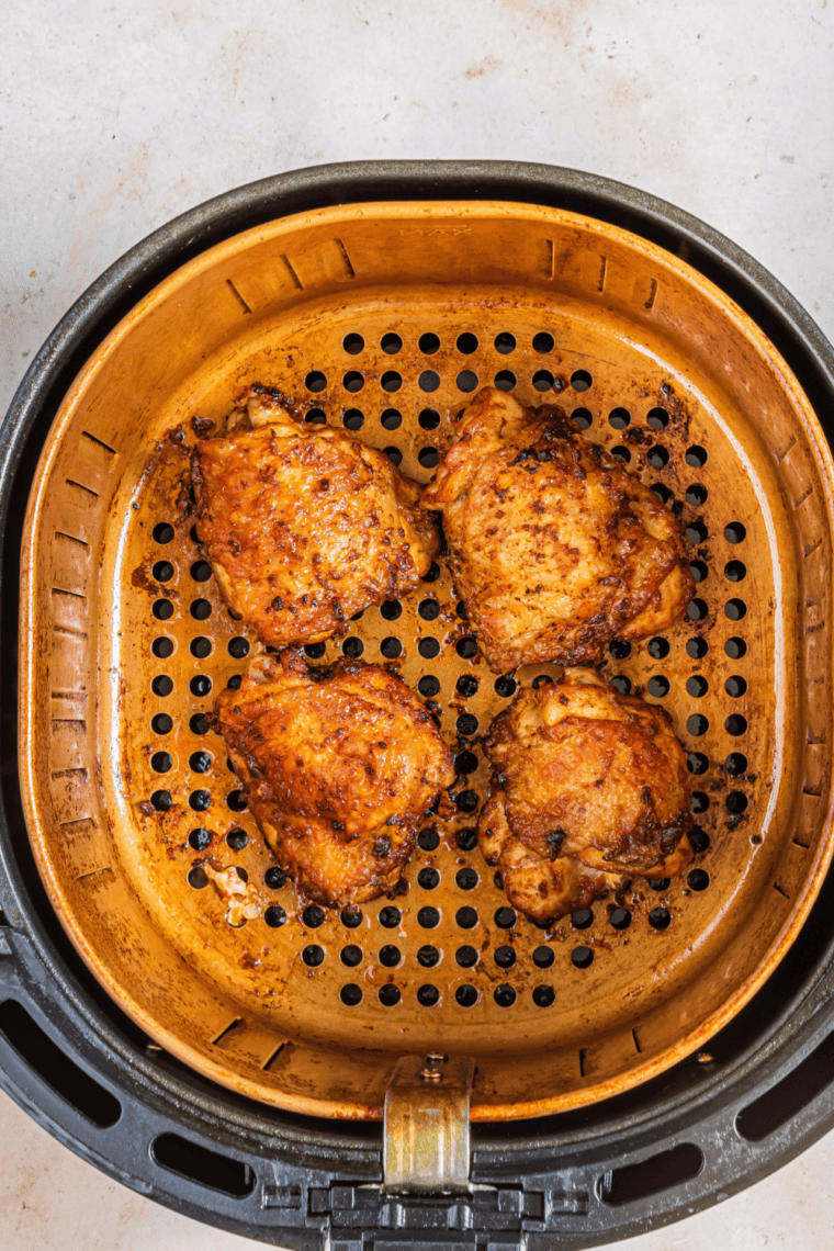 Chicken cooking in the air fryer at 375°F, flipped halfway for even cooking, thermometer checking doneness.